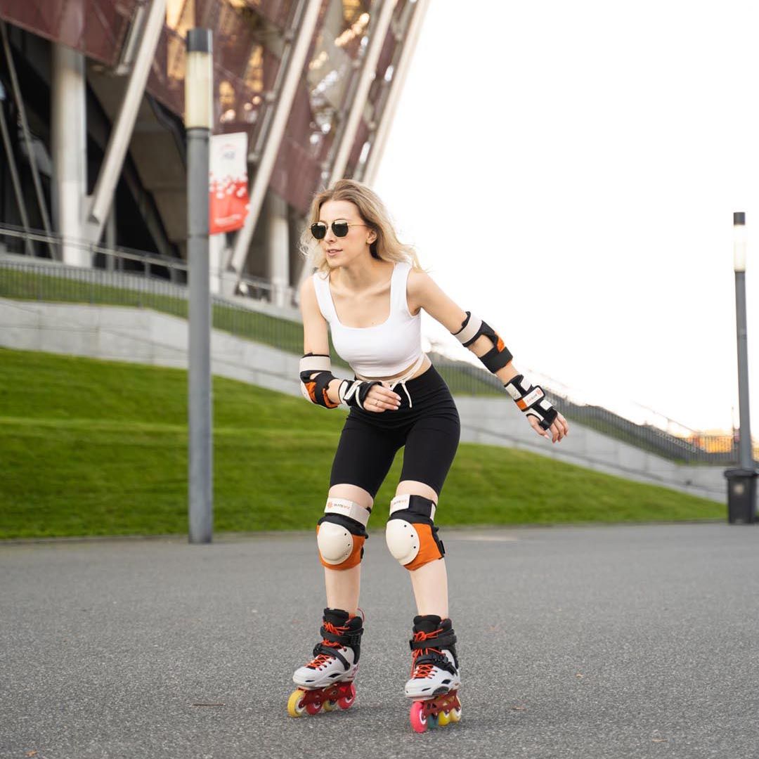Woman inline skating at speed wearing the SKATEWIZ SHIELD set in Sunrise Orange