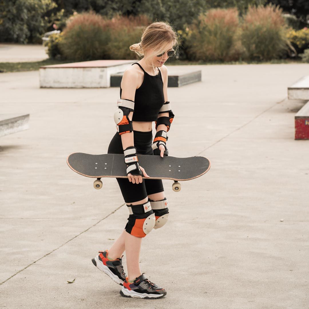 Skateboarder at the park wearing SKATEWIZ knee and elbow pads